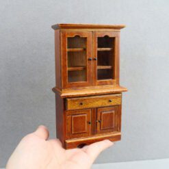 Miniature wooden storage cabinet with shelves and drawers for dollhouses.