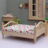 Miniature wooden bed with floral bedding for dollhouse
