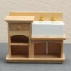 Miniature wooden bathroom sink cabinet with white sink and gold faucets for dollhouses.