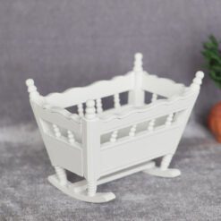White miniature rocking cradle, ideal for nursery dollhouses.