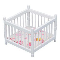 Miniature white baby crib for dollhouse nursery.