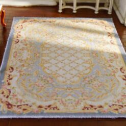 Miniature Aubusson-style rug in pastel blue with floral borders and intricate detailing.