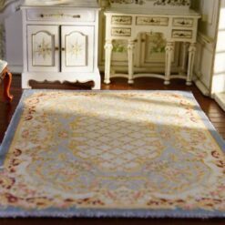 Miniature Aubusson-style rug in pastel blue with floral borders and intricate detailing.