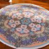 Miniature oriental rug with a colorful floral medallion and intricate detailing.