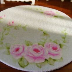 A vintage-inspired miniature rug featuring a soft bouquet of pink roses on a light-colored background.