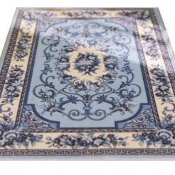 Victorian-inspired miniature rug in blue with floral scrollwork and a central medallion design.