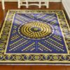 Geometric miniature rug with a spiral pattern of blue and yellow dots, bordered with floral accents.