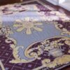 Burgundy miniature rug with yellow floral motifs, featuring a central floral medallion and ornate scrolls.