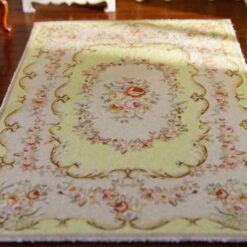 Yellow Aubusson style miniature rug with floral pattern and scroll detailing