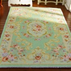 Miniature Victorian rug in soft green with floral patterns and medallion detail.