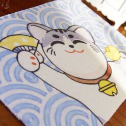Miniature Japanese-style rug with a smiling cat holding a fan and donut, surrounded by blue waves.