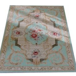 Light blue Victorian miniature rug with a floral medallion and scrolling vine patterns.