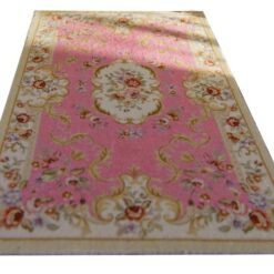Victorian-style miniature rug in soft pink with floral accents and medallion design.