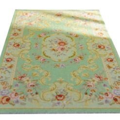 Miniature Victorian rug in soft green with floral patterns and medallion detail.