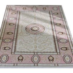 Elegant miniature rug in pink and beige with a floral medallion and intricate borders.