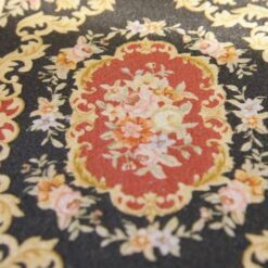 Red and black Aubusson style miniature rug with floral motifs and gold detailing