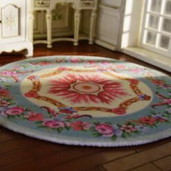 Miniature Victorian-style rug with a floral wreath and rose medallion design in soft colors.