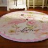 Miniature rug with two pink flamingos surrounded by floral elements and soft colors.