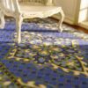 Persian miniature rug with a blue background, golden medallion, and intricate patterns.