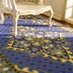 Persian miniature rug with a blue background, golden medallion, and intricate patterns.
