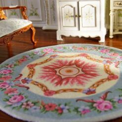 Miniature Victorian-style rug with a floral wreath and rose medallion design in soft colors.
