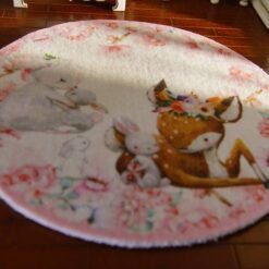 A soft, pastel-colored miniature rug featuring a deer and baby rabbits surrounded by flowers.