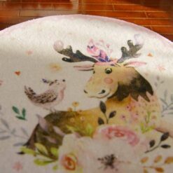 A miniature rug featuring a moose with floral designs and a bird on a white background.