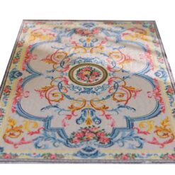 Pastel-colored miniature rug with floral accents and a central floral medallion design.