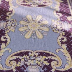 Burgundy miniature rug with yellow floral motifs, featuring a central floral medallion and ornate scrolls.