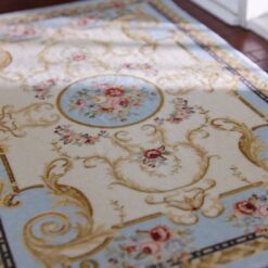Victorian miniature rug with floral scrolls, roses, and a central medallion in soft pastel colors.