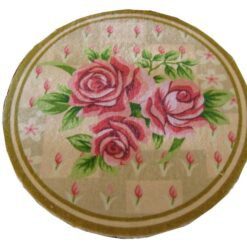 Round miniature rug with pink roses and rose buds on a soft background with a green border.
