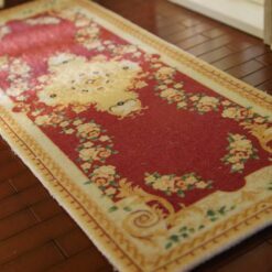 Miniature rug with a red and gold Victorian design, featuring a central medallion and surrounding floral elements.