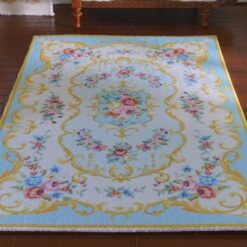 Victorian style miniature rug in pink and yellow with floral motifs and scroll borders