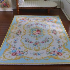 Victorian style miniature rug in pink and yellow with floral motifs and scroll borders