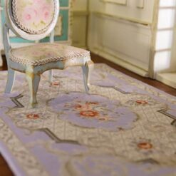 Dollhouse miniature rug with French Aubusson design featuring lavender, cream, and coral floral motifs and ornate scrollwork.