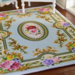 Elegant Blue Victorian Floral Rug for Dollhouses 9 Victorian-style miniature rug with light blue background and floral roses, featuring scrolls and a central medallion.