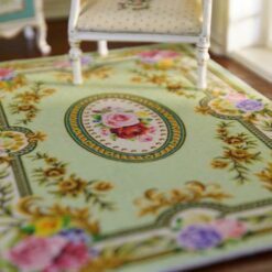 Floral rug with green background and roses surrounding an oval floral center