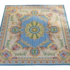 Pastel blue miniature rug with geometric medallions and floral accents, featuring symmetrical design elements.