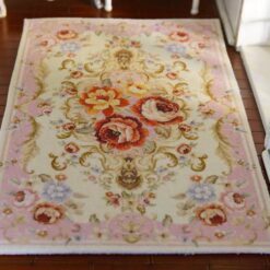 Pink miniature rug with floral scrolls and roses, perfect for adding a romantic touch to any dollhouse.