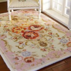 Pink miniature rug with floral scrolls and roses, perfect for adding a romantic touch to any dollhouse.