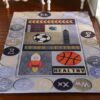 Miniature rug with an educational theme featuring letters, numbers, and playful images like a rocket and basketball.
