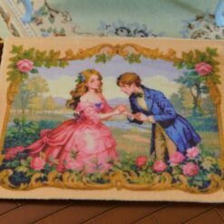 A romantic proposal scene with a couple in vintage attire, surrounded by roses and framed with gold, a miniature Aubusson tapestry.