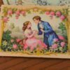Romantic couple in a rose-filled garden with intricate golden borders, a miniature Aubusson tapestry.