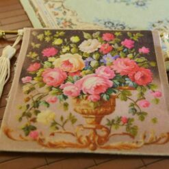 Miniature Aubusson tapestry featuring pastel roses in a golden urn with lush greenery.