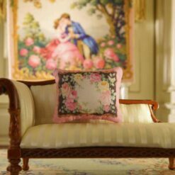 Miniature pillow with a floral border of pink, yellow, and red roses on a black background