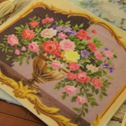 Miniature Aubusson tapestry featuring a sculpted urn with vibrant roses and lush greenery.