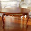 Miniature oval dining table with carved legs and mahogany finish.