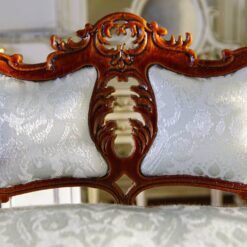 Victorian-style miniature loveseat with carved details and luxurious cushion