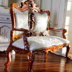 Victorian-style miniature loveseat with carved details and luxurious cushion