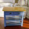 Blue miniature kitchen island with a wooden top and open shelves.
